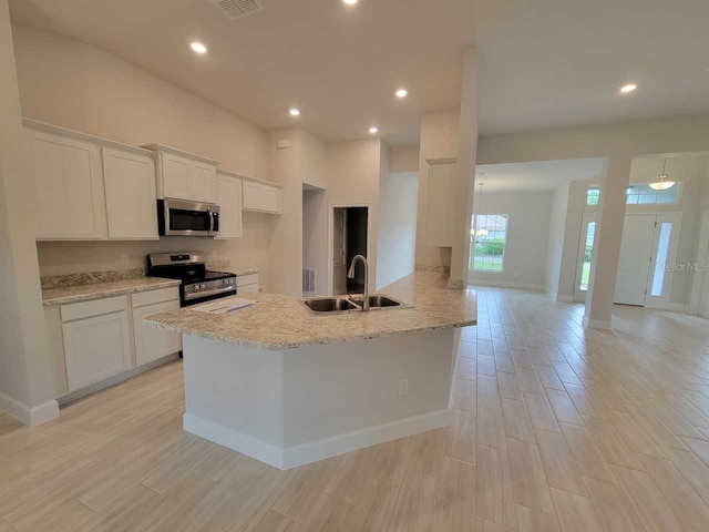 kitchen with white cabinets, stainless steel appliances, recessed lighting, and a sink