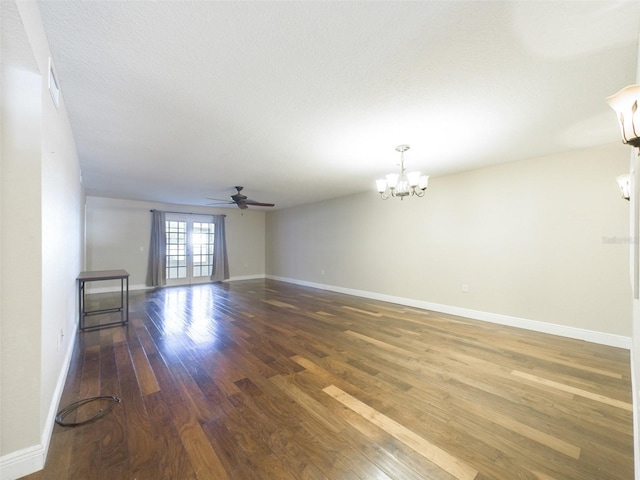 empty room with a textured ceiling, dark wood-type flooring, and ceiling fan with notable chandelier