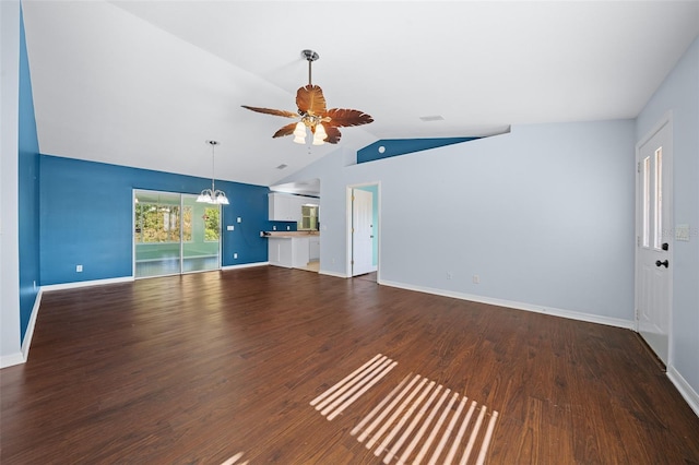 unfurnished living room with hardwood / wood-style floors, ceiling fan with notable chandelier, and vaulted ceiling