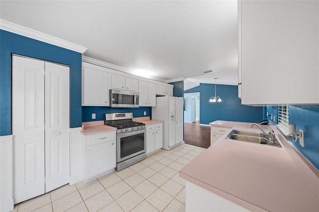 kitchen featuring pendant lighting, white cabinets, sink, crown molding, and stainless steel appliances