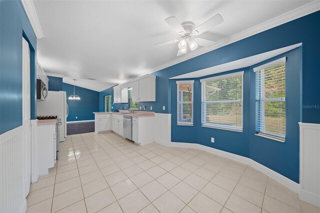 kitchen featuring ceiling fan, white cabinetry, ornamental molding, and appliances with stainless steel finishes