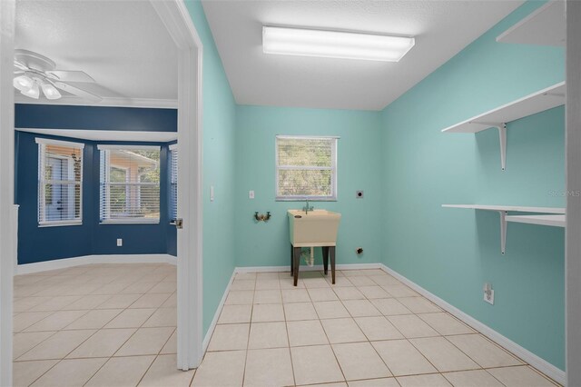 laundry area with hookup for an electric dryer, light tile patterned floors, and ceiling fan