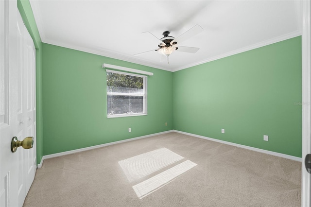 empty room with light colored carpet, ceiling fan, and crown molding