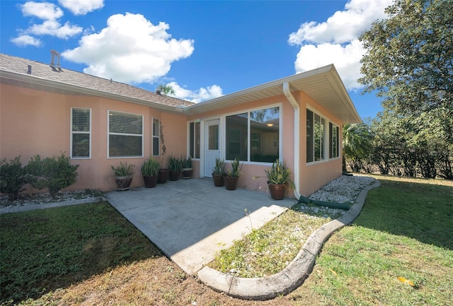 rear view of property featuring a lawn and a patio area