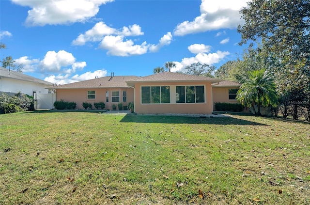 back of property featuring a lawn