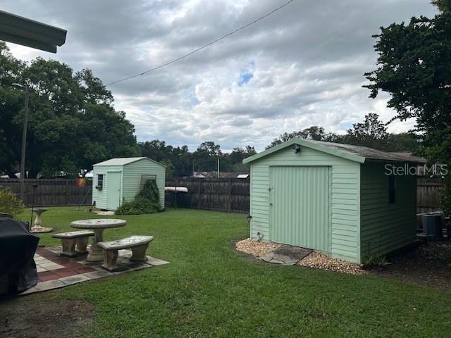 view of yard featuring cooling unit and a shed