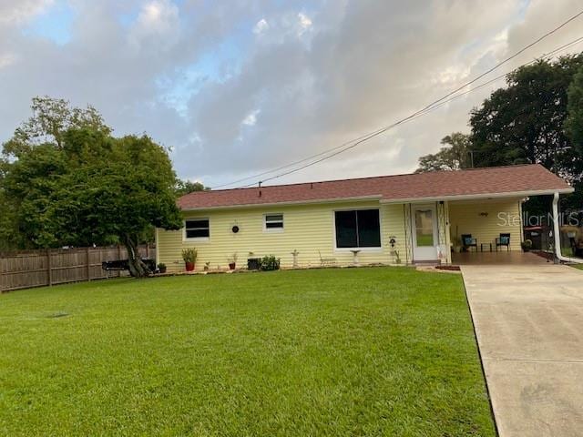 back of property featuring a yard and a carport