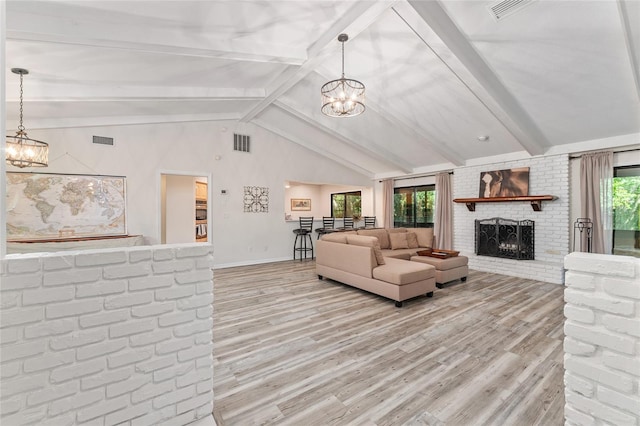 living room featuring lofted ceiling with beams, light hardwood / wood-style floors, a wealth of natural light, and a brick fireplace