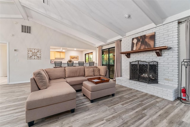 living room featuring a fireplace, lofted ceiling with beams, and hardwood / wood-style flooring