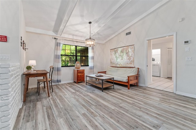 interior space with washer / clothes dryer, light hardwood / wood-style flooring, lofted ceiling with beams, and an inviting chandelier