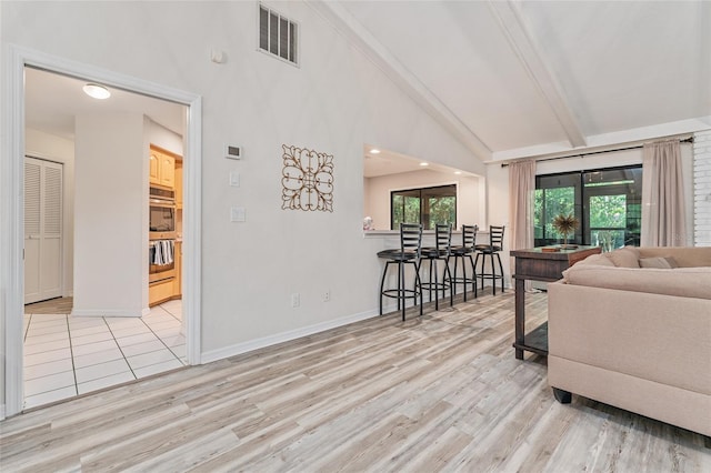 living room featuring beam ceiling, high vaulted ceiling, and light hardwood / wood-style floors