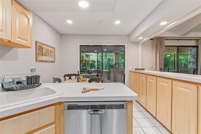 kitchen with light brown cabinetry, light tile patterned floors, stainless steel dishwasher, and sink