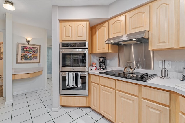 kitchen featuring double oven, light brown cabinetry, light tile patterned flooring, and black stovetop