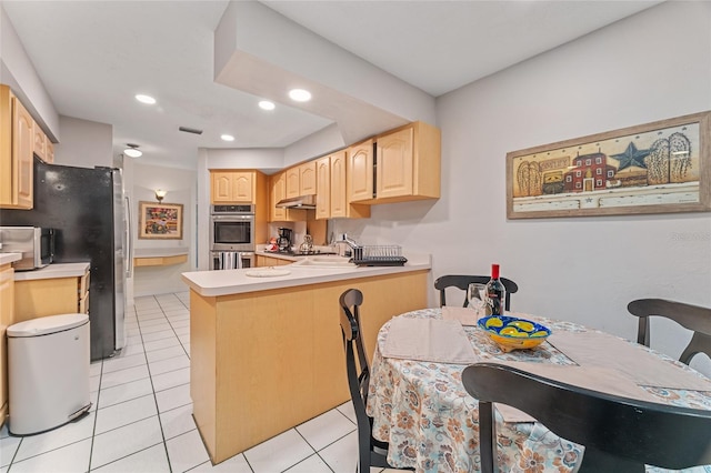 kitchen with kitchen peninsula, light brown cabinetry, light tile patterned floors, and stainless steel appliances