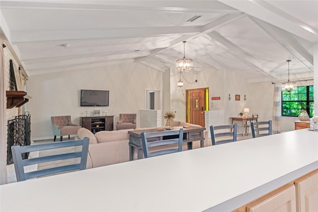 dining space featuring a brick fireplace, lofted ceiling with beams, and an inviting chandelier