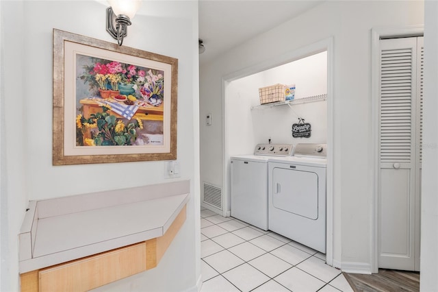 washroom featuring light tile patterned floors and washing machine and clothes dryer