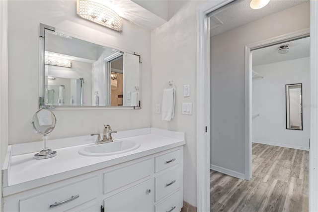 bathroom featuring hardwood / wood-style floors, vanity, and a textured ceiling