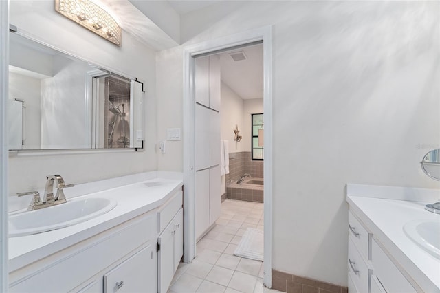 bathroom with vanity, tiled bath, and tile patterned floors