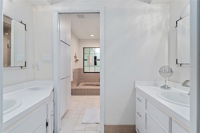 bathroom featuring vanity, tile patterned floors, and tiled tub