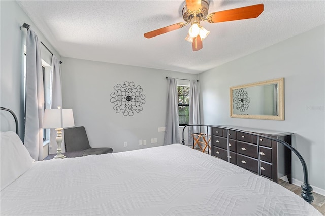 bedroom with wood-type flooring, a textured ceiling, and ceiling fan