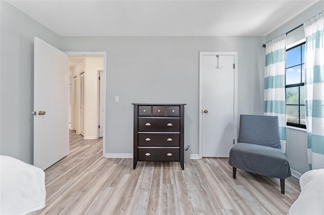 living area with a textured ceiling and light hardwood / wood-style floors