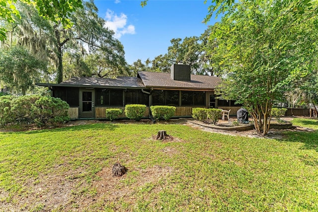 back of property featuring a lawn and a sunroom