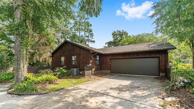 ranch-style house featuring a garage and central AC