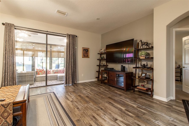 living room featuring wood-type flooring and a textured ceiling