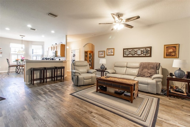 living room with ceiling fan, hardwood / wood-style floors, and a textured ceiling