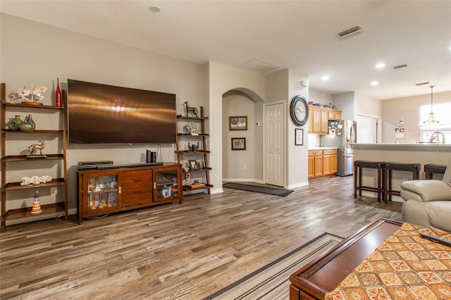 living room featuring a textured ceiling, dark hardwood / wood-style flooring, and sink