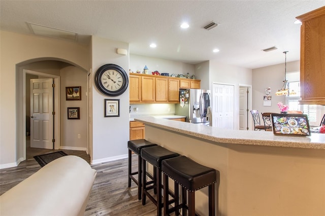 kitchen featuring stainless steel fridge with ice dispenser, a textured ceiling, dark hardwood / wood-style floors, and a notable chandelier