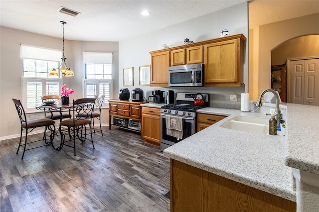 kitchen featuring dark hardwood / wood-style flooring, sink, light stone counters, and stainless steel appliances