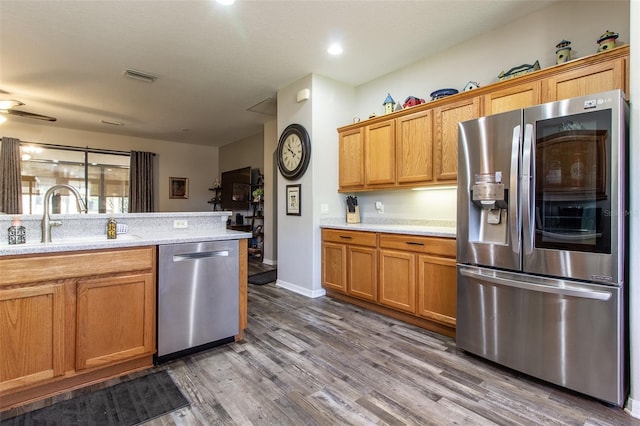 kitchen featuring dark hardwood / wood-style flooring, ceiling fan, sink, and stainless steel appliances