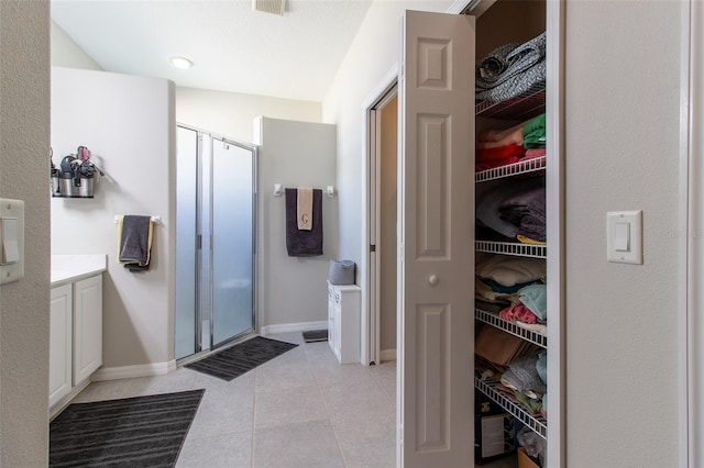 bathroom with tile patterned floors, vanity, and walk in shower