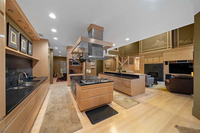 kitchen with a center island, light wood-type flooring, sink, and light brown cabinetry