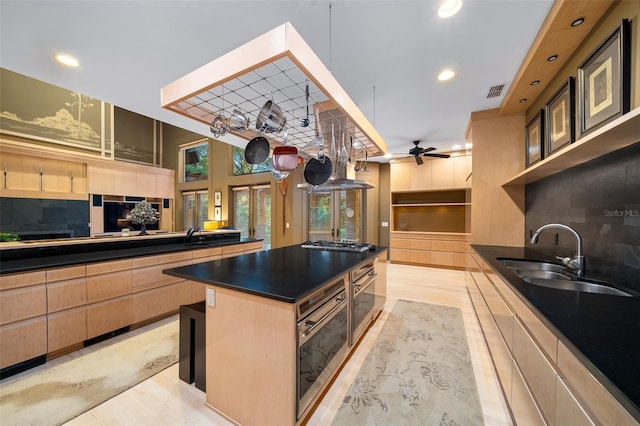 kitchen with ceiling fan, a center island, sink, stainless steel appliances, and tasteful backsplash