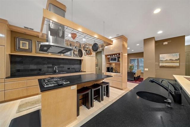 kitchen with backsplash, light hardwood / wood-style floors, and sink