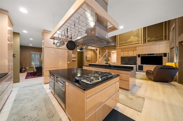 kitchen featuring light wood-type flooring, stainless steel appliances, island range hood, light brown cabinets, and a kitchen island