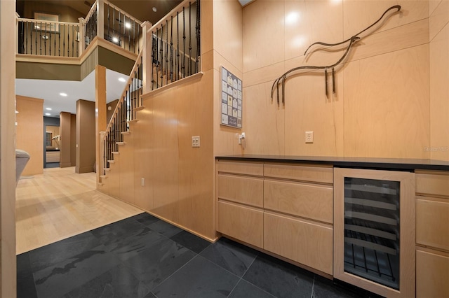 bar with tile patterned flooring, a high ceiling, and wine cooler