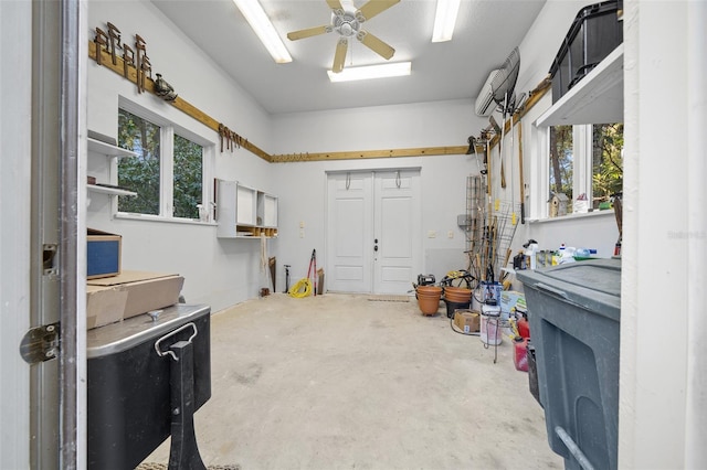 garage featuring an AC wall unit and ceiling fan