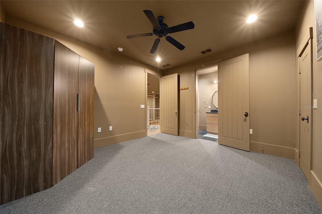 interior space featuring carpet flooring, ensuite bath, and ceiling fan