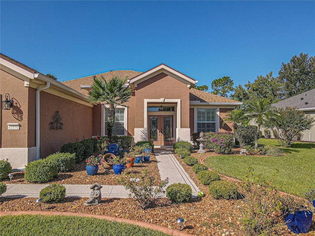 view of front of home with french doors and a front lawn