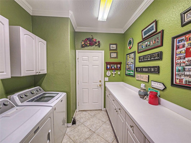 washroom with cabinets, ornamental molding, a textured ceiling, washing machine and dryer, and light tile patterned flooring