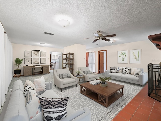 tiled living room with ceiling fan and a textured ceiling