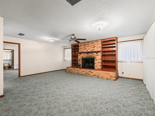 unfurnished living room with carpet, a textured ceiling, and a brick fireplace