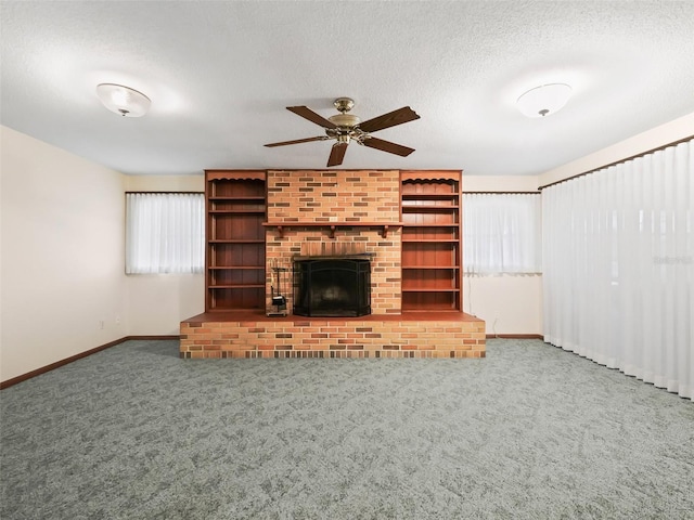 unfurnished living room with ceiling fan, carpet floors, a textured ceiling, and a brick fireplace