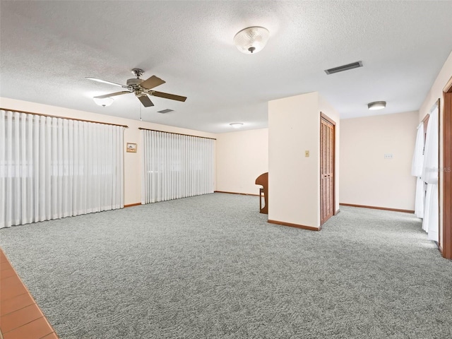 carpeted spare room with ceiling fan and a textured ceiling