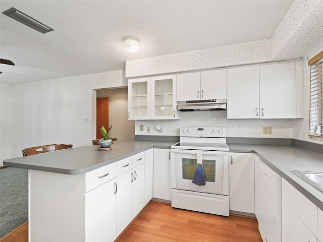 kitchen featuring white cabinetry, kitchen peninsula, light hardwood / wood-style floors, a textured ceiling, and white appliances