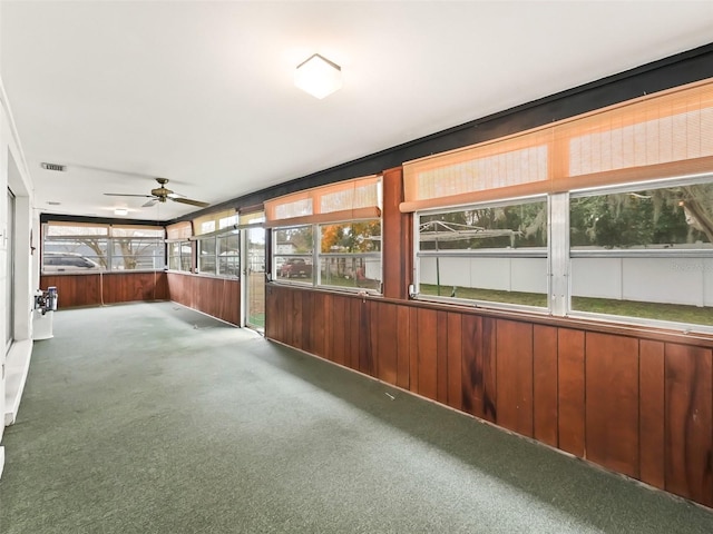 unfurnished sunroom featuring ceiling fan