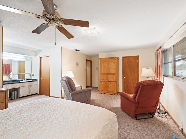 carpeted bedroom with ceiling fan and a textured ceiling